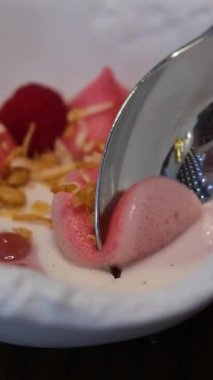 Macro ve Slow Motion 'daki Creamy Kalın Yoğurt' tan Gümüş Kaşıklı Ahududu. Yüksek kalite 4k görüntü