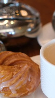 Bahçede ikindi çayı, hamur işleri, tatlılar, milkshake ve cam sehpanın üzerinde kahve. Doğa zeminli açık hava yemek konsepti. Zarif ve sakin bir atmosfer. Yüksek kalite 4k