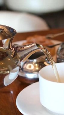 Geleneksel Fas çay servisi gümüş çaydanlık, çay fincanı ve servis tepsisi sunar. Sahne, Fas 'ın zengin kültürünü ve konukseverliğini çağrıştırıyor. Seyahat, kültür ve yaşam tarzı içeriği için mükemmel.. 