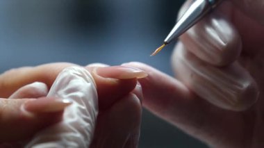 Tırnak Uzatma Uygulaması: Yakından çekilen bir fotoğraf, tırnak uzantısının titiz uygulamasını yakalar, çarpıcı çiviler oluşturmada kullanılan hassasiyet ve sanatsallığı gözler önüne serer. Yüksek kalite 4k görüntü