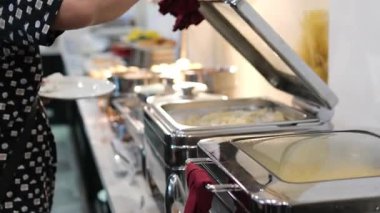 Misafirler et ve sebzeler de dahil olmak üzere bir dizi yemeğin olduğu enfes bir açık büfenin keyfini çıkarırken yerel bir akşam toplantısında kaynaşıyorlar. Yüksek kalite 4k görüntü