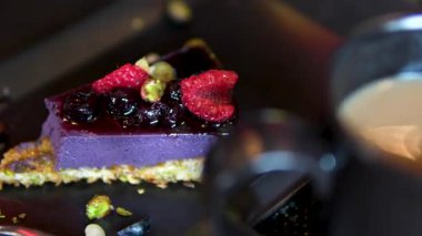 Sütlü veya kahveli bir fincan çay lezzetli çilekli cheesecake yaban mersinli ve buzlu şeker ağız sulandırıcı bir ikramdır. Yüksek kalite 4k görüntü