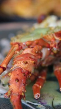 Istakoz kuyruğu ızgarasına yakın çekim. Yanında da yeşil soğanlı sarımsaklı limon yağı sosu. Hazırlık ve Pişirme Sırasındaki Resimleri kapat. Yeşil sarımsak soslu deniz ürünleri ıstakozu.