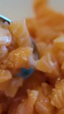 Kesme tahtasına somon parçaları serpiştirmek. Doğranmış çiğ balık.