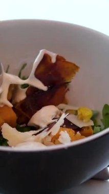 Kadınların elleri evde büyük ahşap kaseden tabağa salata servisi yaparken toplanma sırasında taze yemeği paylaşıyorlar. Yüksek kalite 4k görüntü