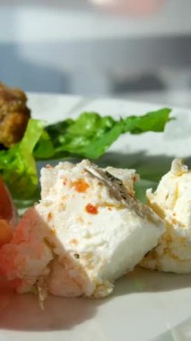 Fresh salad with lettuce leaves and tomato falling into bowl, served with healthy food ingredients on white table, slow motion. High quality 4k footage
