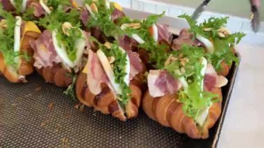 Sandviç pişirirken kruvasana marul koyan kadın eller. Yüksek kalite 4k görüntü