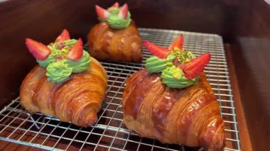 Fıstıklı, ahududulu ve koyu beton kaplamalı çıtır kırmızı kruvasan.