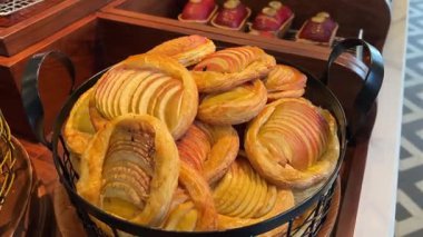 Taze elmalı böreklerle fırın tezgahı. Şeffaf eldiven satın almak için birkaç tane alır. Yakın çekim, yüzü görünmüyor. Yemek severler için çıtır çıtır, altın hamur işleri. Yüksek kalite