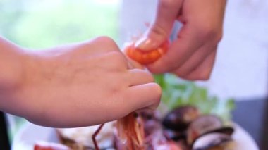 Deniz mahsulleri pişiriyorum. Genç bir kadının elleri mutfakta taze karides soyarken yakından görülüyor. - Evet. Yüksek kalite 4k görüntü
