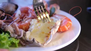 Bir kafede masanın üzerinde duran büyük bir tabakta peynirli fırında midye. Yüksek kalite 4k görüntü