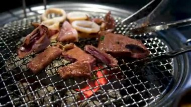 Adam mangalda ahtapot pişirirken dokunaçlarını çeviriyor. Deniz ürünleri dokusu. Yüksek kalite 4k görüntü