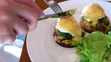 Lokantada Eggs Benedict ile geleneksel İngiliz kahvaltısı. Kek ekmeğine füme somon balığı ve roka salatası. Sağlıklı yiyecekler. Benedict usulü yumurta salatası