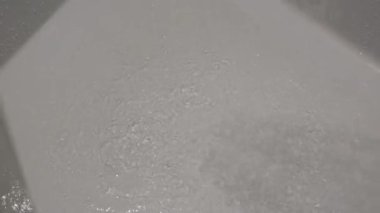 Gümüş krom duş başlığı su sıçratıyor. Banyo modern banyodan akıyor. Yüksek kalite 4k görüntü