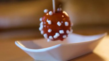 Üzerinde yıldız çıkartması olan çikolata kaplı elmalar servis ediliyor. Noel pazarında elmalar üst üste yığılır. Yüksek kalite 4k görüntü