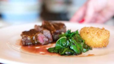 Güneş ışığında taze ıspanak yaprakları, havuç, salatalık ve vişneli domates salatasıyla servis edilen sulu ızgara domuz bifteği. Yüksek kalite 4k görüntü