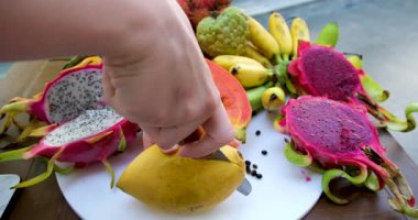 Tayland pazarındaki renkli meyve standı. Çeşitli tropikal meyveler, sebzeler ve yerel ürünler. Sağlıklı beslenme, alışveriş, ticaret, canlı gösteri ve tazelik için ideal. Yüksek kaliteli FullHD görüntüler