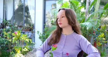 Bahçe için düşünceli bir poz, beyaz kadın mutlu, ilham verici gülümseyen yüz. Pozitif kadın portresi. Neşeli genç yetişkin, sahil otelindeki palmiye ağacının yanında duruyor. Mavi okyanus arka planında.. 