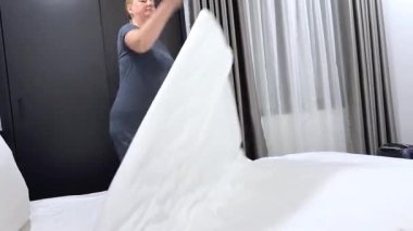 Kadın yorganı atar yatağa uzanır, bacak bacak bacak üstüne atar yorgun yatar. Yüksek kalite 4k görüntü