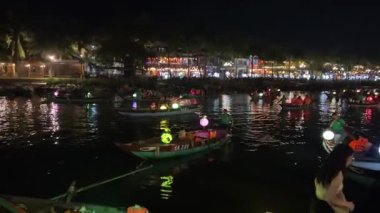 Hoi An Kadim Kasabası, Vietnam 'ın gece manzarası. Thu Bon Nehri 'nde tekneleri aydınlatan kalabalık, canlı atmosferin tadını çıkaran insanlar. Fenerler ve ışıklar sihirli bir şey yaratır. Vietnam Hoi 08.06.2025