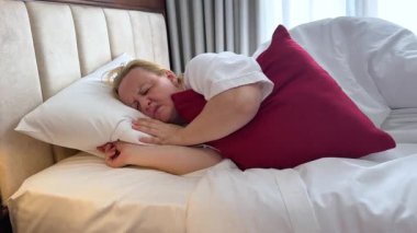 Olgun, yaşlı bir kadın tek başına rahat bir yatakta rahat bir şekilde uyuyor yumuşak yastıkta uyuyor ortopedik yatakta dinleniyor ve iyi geceler uykusu çekiyor. Olgun insan evi rutini 
