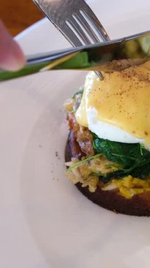 Lokantada Eggs Benedict ile geleneksel İngiliz kahvaltısı. Kek ekmeğine füme somon balığı ve roka salatası. Sağlıklı yiyecekler. Benedict usulü yumurta salatası