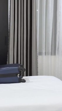 Yatakta oturan bir kadın iş seyahatine çıkmaya hazırlanıyor. Bavulu kapatıyordu. Gelecekteki turist gezisi hakkında endişelerini düşünüp duruyordu. Yüksek kalite 4k görüntü