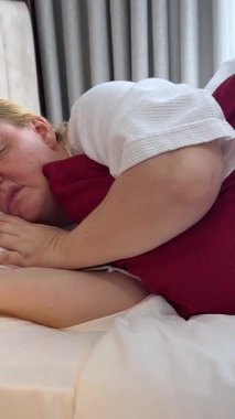 Olgun, yaşlı bir kadın tek başına rahat bir yatakta rahat bir şekilde uyuyor yumuşak yastıkta uyuyor ortopedik yatakta dinleniyor ve iyi geceler uykusu çekiyor. Olgun insan evi rutini 