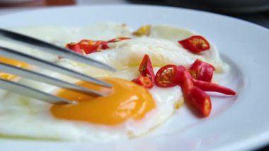 Biberli kahvaltı tabağı, beyaz tabakta kızarmış yumurta ve vişneli domates, yeşil kareli peçeteyle sarı zemin, sağlıklı beslenme kavramı, sabah yemeği.