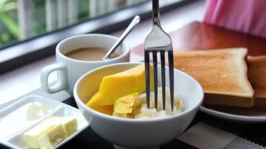 Ahşap zemin üzerinde mangolu tatlı pilav. Mango Asya 'da popüler bir tropikal meyvedir. Yapışkan pirinç ve hindistan cevizi sütüyle servis edilir. Seçici odak ve ücretsiz kopyalama alanı. Sanayi.