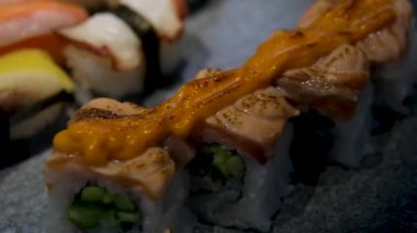 Beyaz bir tabakta servis edilen gurme somon suşi ruloları. Yüksek kalite 4k görüntü