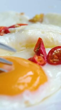 Biberli kahvaltı tabağı, beyaz tabakta kızarmış yumurta ve vişneli domates, yeşil kareli peçeteyle sarı zemin, sağlıklı beslenme kavramı, sabah yemeği.