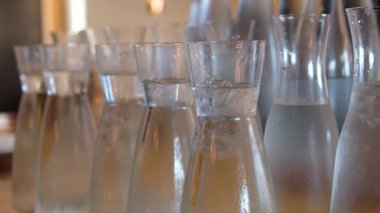 Açık büfedeki tezgahın üzerinde duran birçok cam nilüfer. Sulu sürahiler. Yüksek kalite 4k görüntü