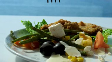 Ahşap kaseden ızgara tavuk salatası yiyen bir kadının yan görüntüsü. Yüksek kalite 4k görüntü