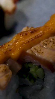 Beyaz bir tabakta servis edilen gurme somon suşi ruloları. Yüksek kalite 4k görüntü