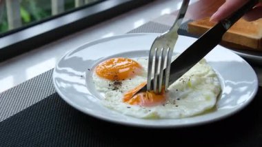 Yeşil tabakta kızarmış yumurta ve ekmek yemek. Yakın plan. Bakış açısı. Renkli arka plan. Tostlu geleneksel kahvaltı. Güneşli bir gün. Yüksek kalite 4k görüntü