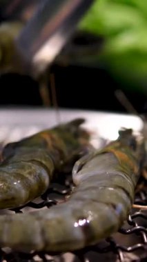 El, ızgara biftek ve karides fajitaları servis etmek için çatal kullanır. Cızırdayan sıcak tavadan, sıcacık aydınlatılmış restoran ortamında renkli bir tabağa. Yüksek kalite 4k görüntü