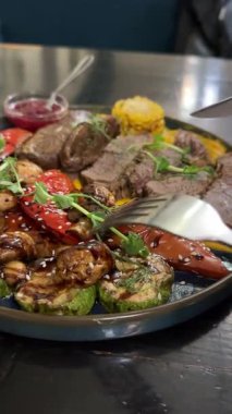 Kızarmış kırmızı kiraz soslu haşlanmış sığır eti ızgara sebzeler roka mikroyeşillikleri lezzetli restoran servisleri. Yüksek kalite 4k görüntü