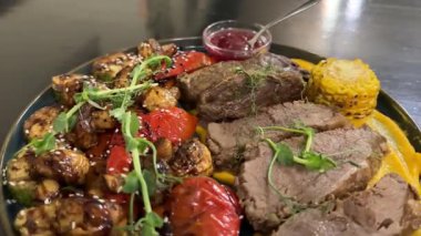 Kızarmış kırmızı kiraz soslu haşlanmış sığır eti ızgara sebzeler roka mikroyeşillikleri lezzetli restoran servisleri. Yüksek kalite 4k görüntü