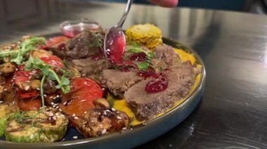 Kızarmış kırmızı kiraz soslu haşlanmış sığır eti ızgara sebzeler roka mikroyeşillikleri lezzetli restoran servisleri. Yüksek kalite 4k görüntü