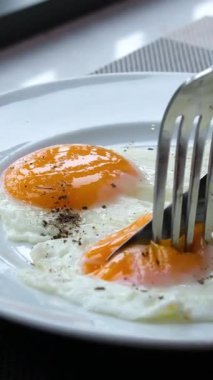 Yeşil tabakta kızarmış yumurta ve ekmek yemek. Yakın plan. Bakış açısı. Renkli arka plan. Tostlu geleneksel kahvaltı. Güneşli bir gün. Yüksek kalite 4k görüntü