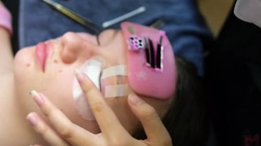 Kirpik uzatma prosedürü. Uzun kirpikli kadın gözü. Kırbaç, yakın çekim, seçici odaklanma. Yüksek kalite 4k görüntü