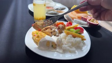 Otelin lezzetli kahvaltısında çırpılmış yumurtaları mayonezin içine daldırıp sebzeli pilavın üzerine koy. Yüksek kalite 4k görüntü