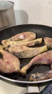 Kadın fırında pişirmek için pastik torbaya balık koyar. Gümüş sazan pişirir