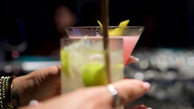 Elinde şampanya bardakları tutan bir kız, bir erkekle kadeh kaldırıyor. Le coupe kokteyl bardakları. Yeni yılı ya da şirket tatilini kutlar. Disko ya da retro tarzı. Kadehleri tokuştururlar, bardakları tokuştururlar.