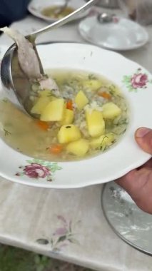 Balık çorbası Ladle, ocağın üstünde patates ve bezelye ile kaynayan kemik suyunda karışımı karıştırır. Ev yemeği sırasında çorba hazırlama yakın çekim. Yüksek kalite 4k görüntü
