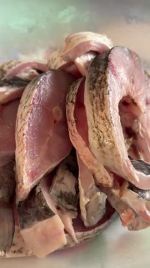 Gümüş sazan balığı parçaları taze gümüş sazan balığı hazırlar. Bıçakla bifteğe kesiyor. Ev yemeği konsepti. Yüksek kalite 4k görüntü