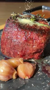 Biberli biftek üzerine karabiber serpin. Kavram: Et pişirme süreci. Bir kadın et pişirir. Yüksek kalite 4k görüntü