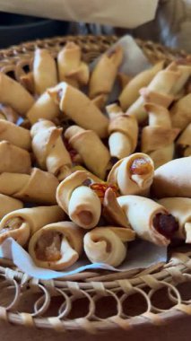 Sepet hamur işleri lüks otel kahvaltı büfesi veya fırın pazarında taze ekmek ruloları, kırsal hasır sepetlerde zanaatkar hamur işleri ve krakerler sergileniyor. Yüksek kalite 4k görüntü