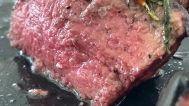 Şef taze ızgara et dilimliyor. Mutfaktaki tahta kesme tahtasının üzerinde bıçakla, yakın plan yiyeceklerle. Yüksek kalite 4k görüntü